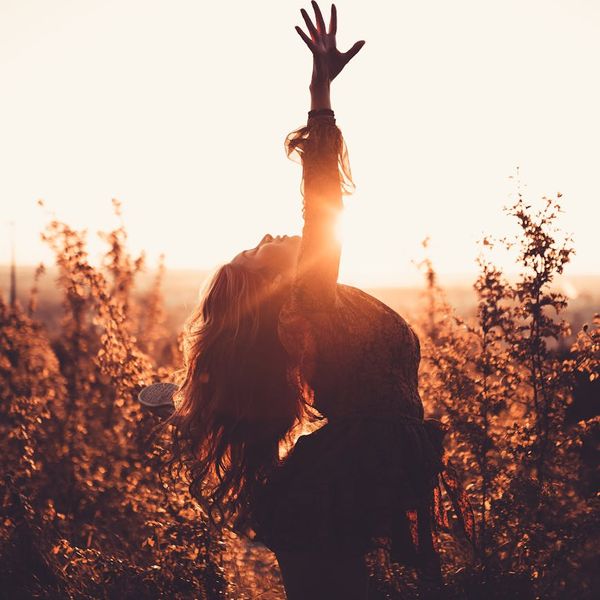 Silhouette of a woman stretching, glowing with inner energy.
